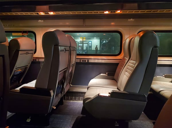 Padded vinyl train seats in the foreground, and the Olympia station out the window.